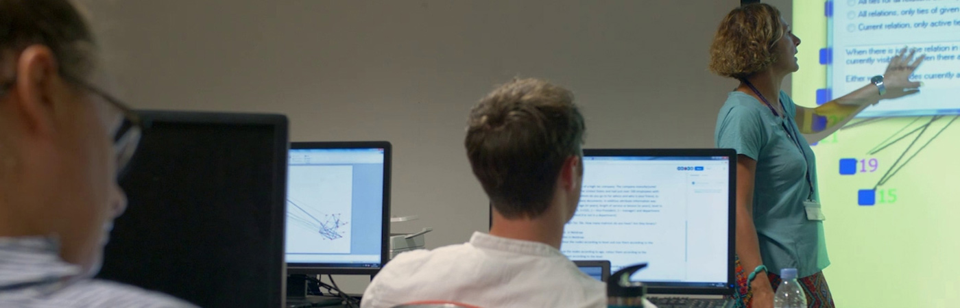 students at a lecture with PCs and presentation screen